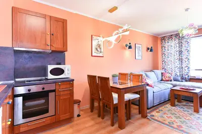 a kitchen and living room with a table and a couch at Cedar Lodge III - One BDRM Flat B18 in Bansko