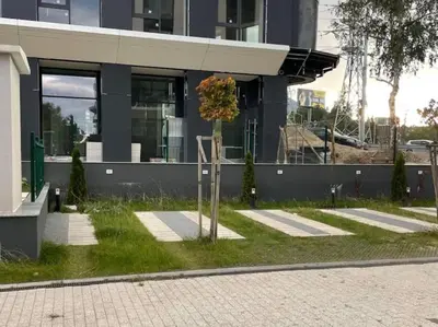 a tree in the grass in front of a building at Via310 by Cosher in Sofia