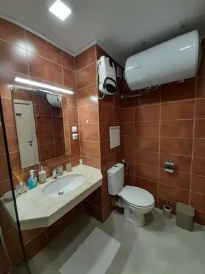 a bathroom with a toilet and a sink and a mirror at Lux Apartament 4403 near the ski lift in Bansko