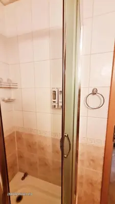 a shower with a glass door in a bathroom at Приветливо смарт студио, с изглед към Снежанка и ски писта Пампорово-Стойките in Stoykite