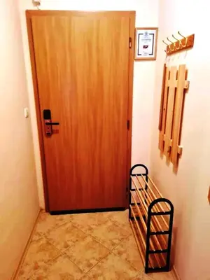 a hallway with a wooden door and a shelf next to it at Приветливо смарт студио, с изглед към Снежанка и ски писта Пампорово-Стойките in Stoykite