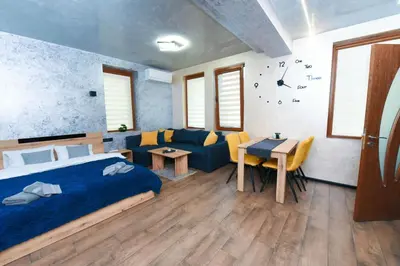a bedroom with a bed and a couch and a table at Студио Анастасия in Smolyan