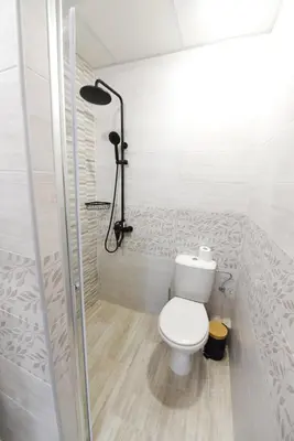 a white bathroom with a toilet and a shower at Студио Анастасия in Smolyan