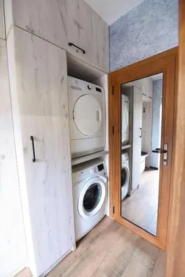 a laundry room with a washing machine and a mirror at Студио Анастасия in Smolyan