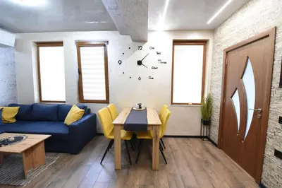 a living room with a blue couch and a table at Студио Анастасия in Smolyan
