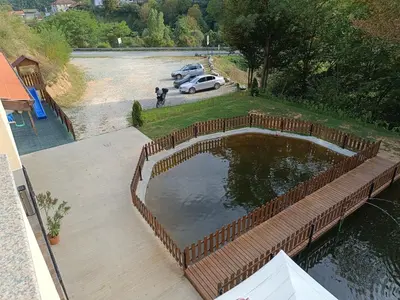 a pond with a fence around it on a patio at Комплекс Кантона in Razhishte