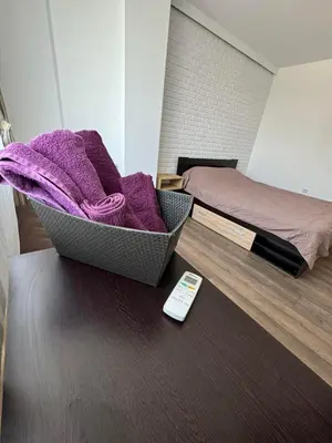 a remote control sitting on a table next to a bed at Апартамент LiAn in Plovdiv