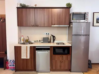 a kitchen with a stainless steel refrigerator and wooden cabinets at Bansko&Ski in Bansko