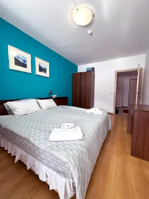 a bedroom with a large bed with a blue wall at Bansko&Ski in Bansko