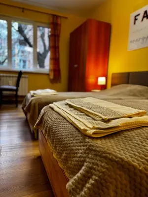two beds in a bedroom with a window at Oborishte Family Elegance with Garden View in Sofia
