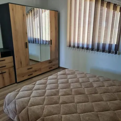 a bedroom with a large bed and a mirror at Вила Хадживезула in Yokoruda