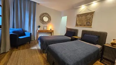 a hotel room with two beds and a chair at MONTEVERDE Tamplier in Bansko
