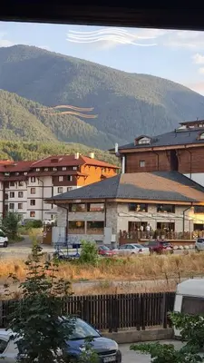 a large building with cars parked in a parking lot at MONTEVERDE Tamplier in Bansko