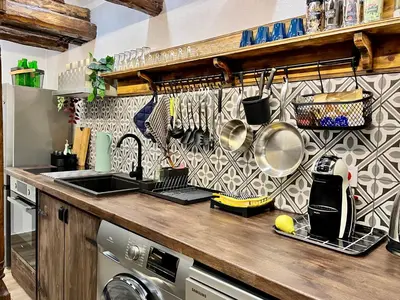 a kitchen counter with pots and pans on a wall at Туйковата къща The Tuikov House in Teteven