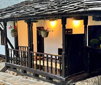 a cottage with a gazebo with potted plants at Туйковата къща The Tuikov House in Teteven