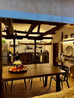 a table in a kitchen with a bowl of fruit on it at Туйковата къща The Tuikov House in Teteven