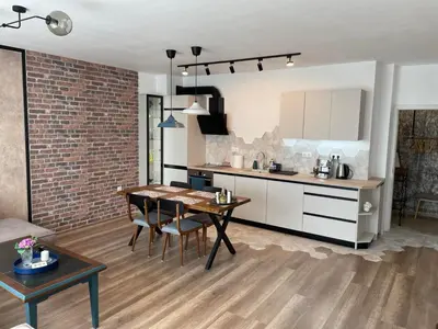 a kitchen and living room with a table and a kitchen and a dining room at Platinum Luxury Industrial Unit City-Center in Plovdiv