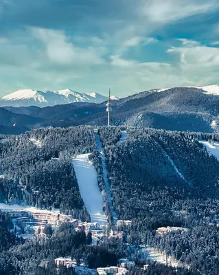 a cross on top of a mountain with a city at GS SKI Apartment - The Grand Monastery Pamporovo in Pamporovo