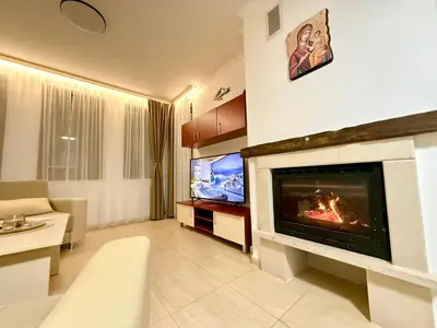 a living room with a fireplace and a tv at GS SKI Apartment - The Grand Monastery Pamporovo in Pamporovo