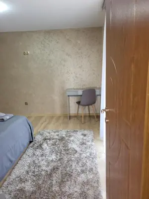 a bedroom with a bed and a desk and a door at Панорамен Пентхаус - Кабинков лифт - 3 спални in Bansko