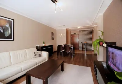 a living room with a white couch and a table at Apartments Carrera in Sofia