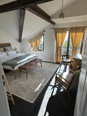 a bedroom with a bed and a chair and windows at Newly Built Family Villa with a Hot Tub in Sopot