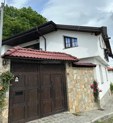a house with a garage with a brown garage door at Newly Built Family Villa with a Hot Tub in Sopot