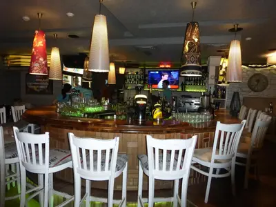 a bar with white chairs and a counter in a restaurant at Two-Bedroom Apartment in Fortuna in Bansko