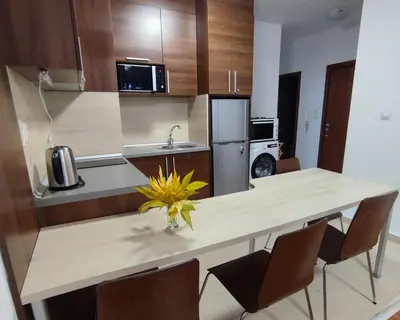 a kitchen with a table with chairs and a sink at Belvedere Holiday Club 2Bedroom Apartment F201 in Bansko