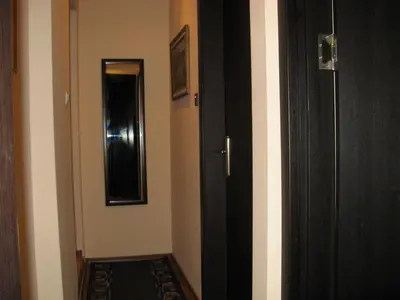a hallway with a black door and a mirror at Kapana Plovdiv in Plovdiv