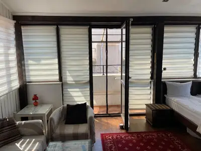 a bedroom with a bed and a couch and windows at Kapana Plovdiv in Plovdiv