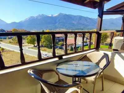 a table and chairs on a balcony with mountains at 