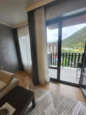 a living room with a couch and a large window at Apartment in Hotel Sveti Spas 5 Velingrad in Velingrad
