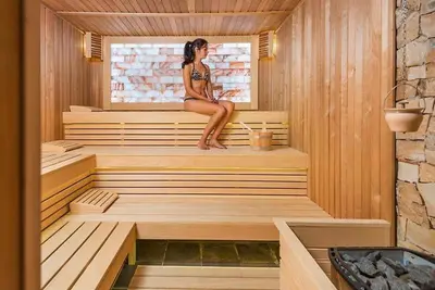 a woman sitting on the edge of a sauna at Apartment in Hotel Sveti Spas 5 Velingrad in Velingrad