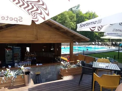 a restaurant with a pool in the background with tables and chairs at Apartment in Hotel Sveti Spas 5 Velingrad in Velingrad