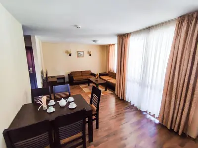 a dining room with a table and chairs and a living room at Dream 1BRoom Private Apartment in Bansko