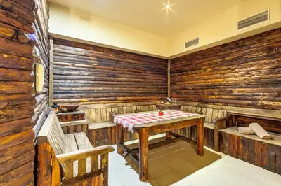a room with a table and chairs in a room with wooden walls at Dream 1BRoom Private Apartment in Bansko