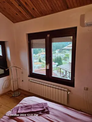 a bedroom with a window with a view of a deck at Villa Dilyanka Stokite in Stoykite