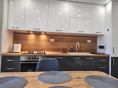 a kitchen with white cabinets and a wooden table at Boutique apartment yellow 1 in Plovdiv