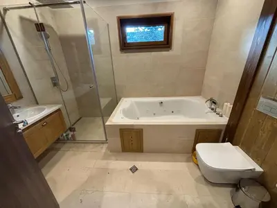 a bathroom with a tub and a toilet and a shower at Villa Pirin Golf in Bansko