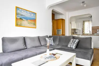 a living room with a gray couch and a table at Large 2-BR Retreat, Walk to Sofias Top Spots in Sofia