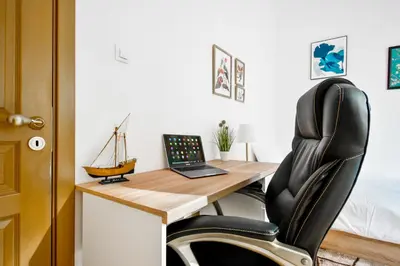 a office with a desk with a laptop and a chair at Large 2-BR Retreat, Walk to Sofias Top Spots in Sofia