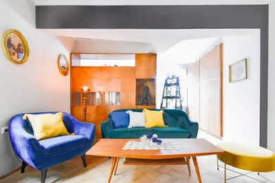 a living room with a blue couch and a table at Creative 70s-Inspired Stay Center Parking in Sofia