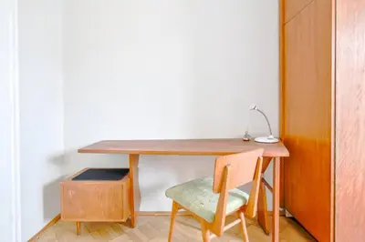 a wooden desk with a chair next to a table at Creative 70s-Inspired Stay Center Parking in Sofia