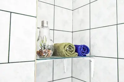 a glass bottle sitting on a shelf in a bathroom at Creative 70s-Inspired Stay Center Parking in Sofia