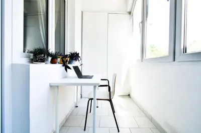 a white table with a laptop on it in a room with windows at Prime Spot - 2BR -15BTH - Next to Nevsky Church in Sofia