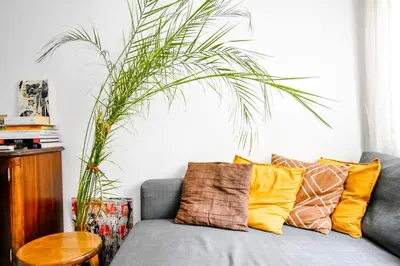 a living room with a gray couch with pillows at 1BDR Quiet Str Vitoshka Area AC in Sofia