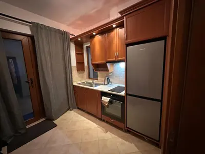 a kitchen with wooden cabinets and a sink and a refrigerator at Villa Vista in Dolna Banya