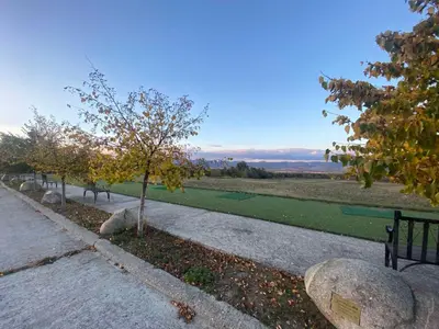 a park with benches next to a green field at Villa Vista in Dolna Banya