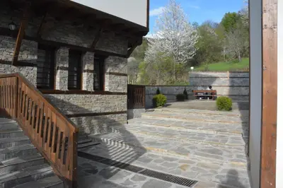 a patio with stairs and a bench on a building at Leshtenski Perli in Leshten